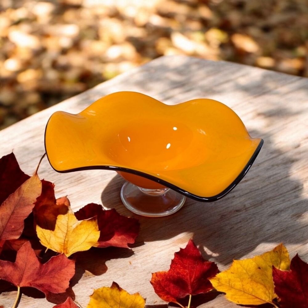 Vibrant orange glass bowl with ruffled rim on clear pedestal by Teleflora.